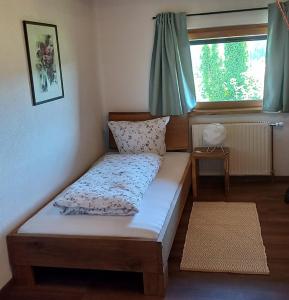 a bed sitting in a room with a window at Huis am Berg in Immenstadt im Allgäu