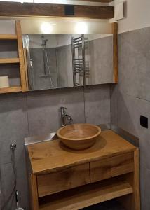 a bathroom with a wooden bowl sink and a mirror at Huis am Berg in Immenstadt im Allgäu