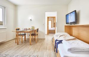 a room with a bed and a table with a tv at Haus Pamir _ Fewo 22 in Cuxhaven