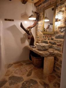 a stone bathroom with a sink and a mirror at Dimitrakis Guesthouse in Donoussa +69 photos