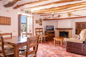 a living room with a table and a fireplace at Cortijo La Presa in Priego de Córdoba