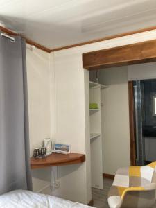 ein Schlafzimmer mit einem Bett und einem Holzregal in der Unterkunft La Petite Escale du Maïdo in Saint-Paul