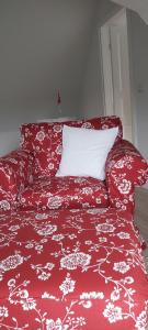 a red couch with a red and white blanket at Ferienhaus Deichblick in Tönning