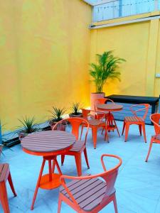 een patio met tafels en stoelen en een gele muur bij 好客輕旅 in Donggang