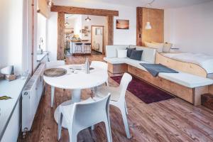 Zimmer mit einem weißen Tisch, Stühlen und einem Bett in der Unterkunft Studio Apartment zur alten Post, 48qm Individualapartment mit Blick über Zittaus Altstadt, Ferienwohnung im Altstadtkern umrandet vom Zittauer Gebirge in Zittau