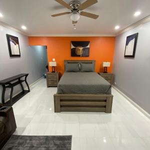 - une chambre avec un lit et un mur orange dans l'établissement K&S SEAVIEW luxury apartment, à Montego Bay