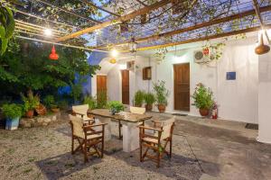 un patio con mesa, sillas y plantas en Platanakia en Skopelos Town