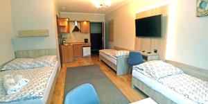 a small room with two beds and a kitchen at Willa Sternik in Hel