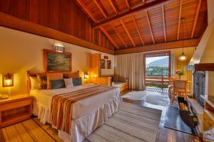 a hotel room with a bed and a balcony at Hotel & Spa Saint Michel in Monte Verde