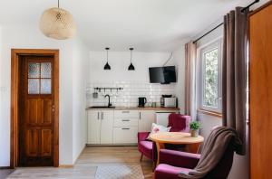 a kitchen with a table and two chairs and a table at Domki nad potokiem in Susiec