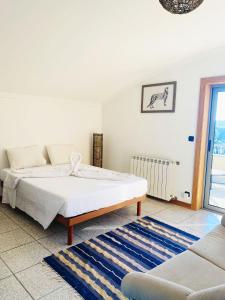 a white bedroom with a bed and a couch at Cabedelo guest house in Viana do Castelo