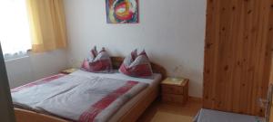 フィーバーブルンにあるハウス フルーヴァインのベッドルーム1室(赤と白の枕が備わるベッド1台付)