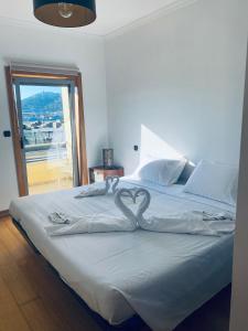 Un dormitorio con una cama grande con un corazón. en Cabedelo guest house, en Viana do Castelo