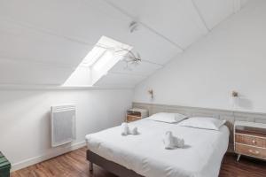 a bedroom with a large white bed with a skylight at Maison Ferry - Welkeys in Rivedoux-Plage