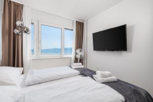 a bedroom with two beds and a flat screen tv at Heaven View Apartment in Rijeka