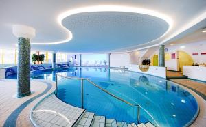 ein großer Pool in einem Gebäude in der Unterkunft Hotel Manggei Designhotel Obertauern in Obertauern