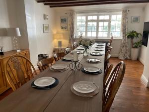 a dining room table with chairs and a long wooden table at Bozeat Retreat & York Cottage Spa in Bozeat