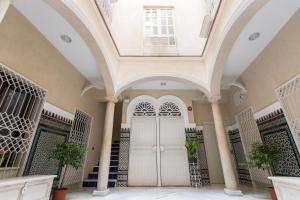 um edifício com um arco e uma porta branca em Apartamentos Plaza Nueva em Sevilha