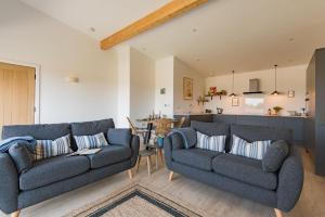 a living room with two couches and a kitchen at The Bull Pen by Bloom Stays in Stalisfield