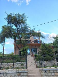 una casa con scale e un albero sullo sfondo di Bora kuće na reci a Belgrado