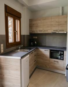 a kitchen with wooden cabinets and a sink at Sisaion Suites - Live the Cretan Hospitality in Metókhion Apisianá +30 photos