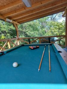 a pool table with three cue balls and bats on it at Bora kuće na reci in Belgrade