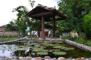 a pond with a gazebo in a garden at The Old House Guest House in Obedinenie