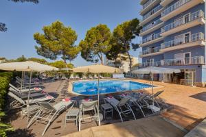 basen w hotelu z krzesłami i parasolami w obiekcie JS Paradise Sport - Adults Only w El Arenal