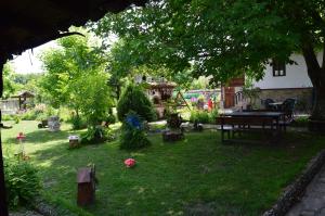 un patio trasero con una mesa de picnic y una mesa de picnic Sidx Sidx en The Old House Guest House, en Obedinenie