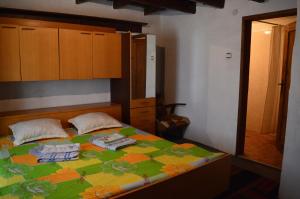 Un dormitorio con una cama con un edredón colorido. en The Old House Guest House, en Obedinenie