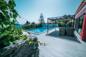 a house with a swimming pool and a patio at Casa Maravilha in Caniço