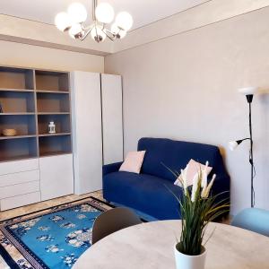 un soggiorno con divano blu e tavolo di Attico Guest House a Cremona