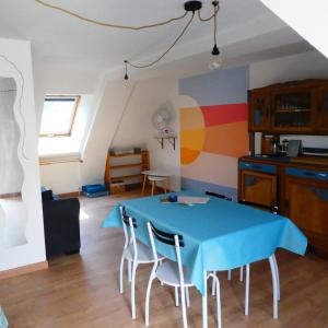 a dining room with a blue table and chairs at Gîte insolite dans la Microbrasserie & Auberge Ortan in La Canourgue