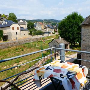 a table on a balcony with a view of a town at Gîte insolite dans la Microbrasserie & Auberge Ortan in La Canourgue