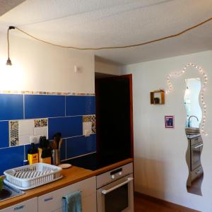 a kitchen with blue tiles on the wall at Gîte insolite dans la Microbrasserie & Auberge Ortan in La Canourgue