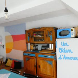 una cucina con armadio in legno e frigorifero di Gîte insolite dans la Microbrasserie & Auberge Ortan a La Canourgue