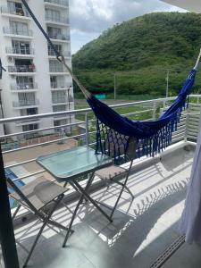 a hammock and a table on a balcony with a building at Aqualina Green Girardot in Girardot