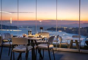 a dining room with a table and chairs on a balcony at Divine Cave Experience in Imerovigli