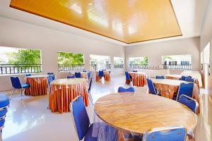 una stanza con tavoli, sedie e finestre di Collection O 91046 Hotel Remaja Indah Masamba a Masamba