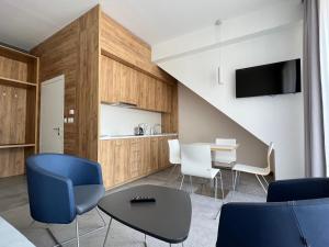 a living room with a table and chairs and a tv at Aparthotel Apartamenty Czarna Góra 417 in Sienna