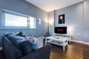 a living room with a couch and a tv at Versace Inspired Apartment in Liverpool