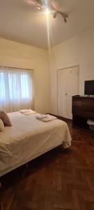a bedroom with a bed and a dresser and a window at Hermoso Dpto. en el Corazón de Salta Capital in Salta