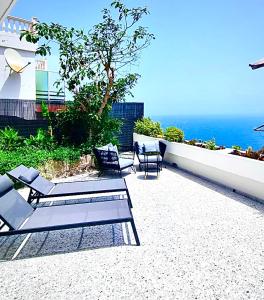 ロス・レアレホスにあるEl Drago Apartment, Amazing Ocean & Cliff Viewの海を見渡すパティオ(椅子付)