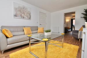 a living room with a couch and a glass table at Canalview House - Fully Furnished Coventry City Centre Home in Coventry