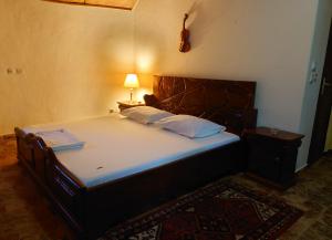 a bed in a bedroom with a lamp on a table at Rundbungalow auf Lionsrest in Grand-Bassam