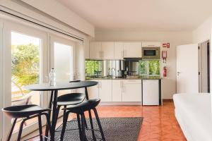 a kitchen with a table and chairs in a room at Costa d'Oiro Ambiance Village in Lagos