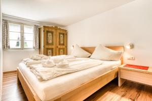 a large bed with white sheets and bowls on it at Chalet Mariedl in Schruns-Tschagguns