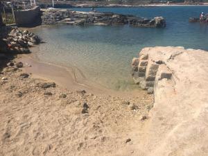 a beach with rocks and the water at Almarea Blu - appartamento in villa vicino al mare - affitto breve in Polignano a Mare