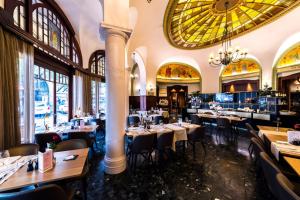 a dining room with tables and chairs and a chandelier at Studios Astra Hotel Vevey in Vevey +13 photos