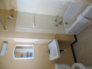 a small bathroom with a toilet and a sink at Lincoln Lodge Motel in Clarks Hill